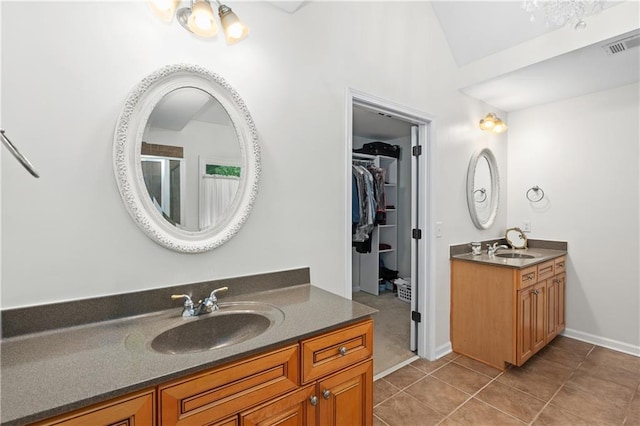 5725 Lake Oak Lndg, Cumming, GA 30040 - bathroom with two vanities, vaulted ceiling, tile patterned flooring, a walk in closet, and a shower