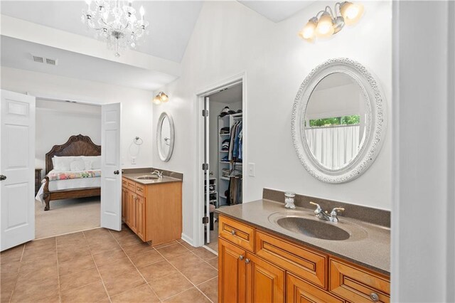 5725 Lake Oak Lndg, Cumming, GA 30040 - ensuite bathroom featuring tile patterned floors, two vanities, lofted ceiling, a chandelier, and a spacious closet