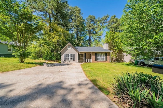 ranch-style home featuring brick siding, a front lawn, and driveway