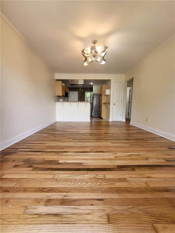 40 Daniel St SE Unit 7, Atlanta, GA 30312 - unfurnished living room with baseboards, wood finished floors, an inviting chandelier, and crown molding