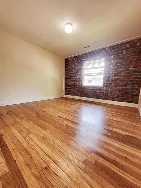 40 Daniel St SE Unit 7, Atlanta, GA 30312 - empty room featuring hardwood / wood-style flooring, brick wall, baseboards, and visible vents