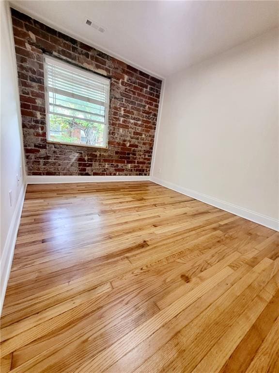 40 Daniel St SE Unit 7, Atlanta, GA 30312 - spare room with wood finished floors, visible vents, baseboards, and brick wall