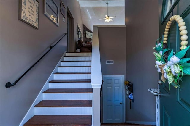 staircase featuring ceiling fan