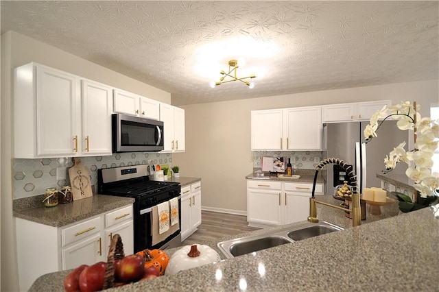 kitchen featuring white cabinetry, stainless steel appliances, dark wood-type flooring, and sink