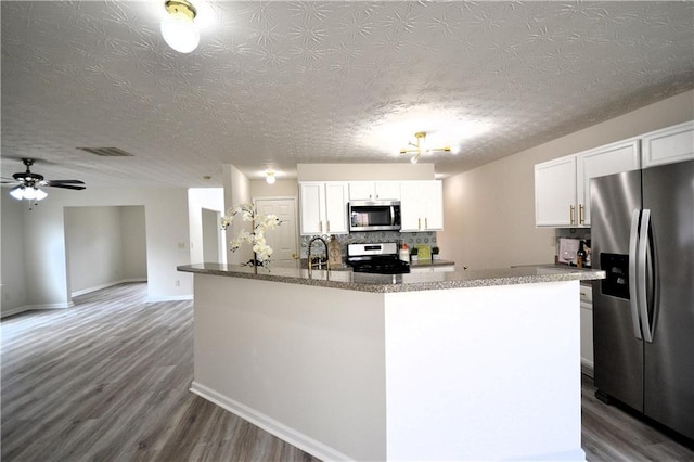 kitchen featuring a center island, white cabinetry, stainless steel appliances, and wood-type flooring