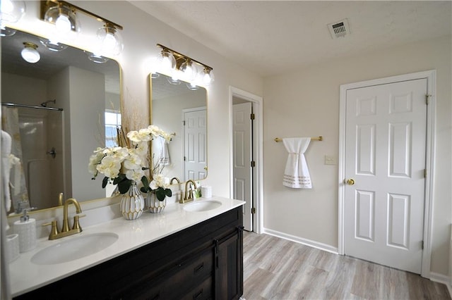 bathroom featuring vanity, walk in shower, and wood-type flooring