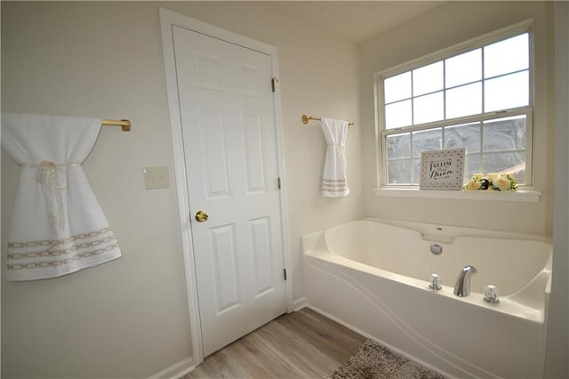 bathroom with wood-type flooring and a tub