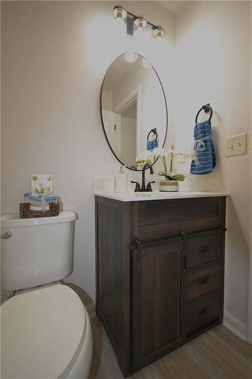 bathroom with vanity, wood-type flooring, and toilet