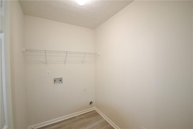 laundry room featuring washer hookup, a textured ceiling, wood-type flooring, and electric dryer hookup