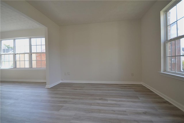 unfurnished room featuring a textured ceiling and light wood-type flooring