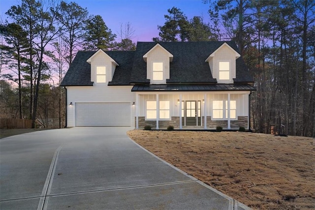 cape cod-style house with covered porch and a garage