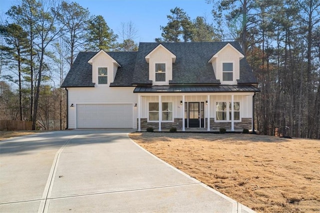 new england style home with covered porch and a garage