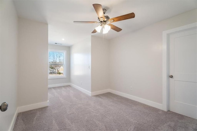 carpeted spare room featuring ceiling fan