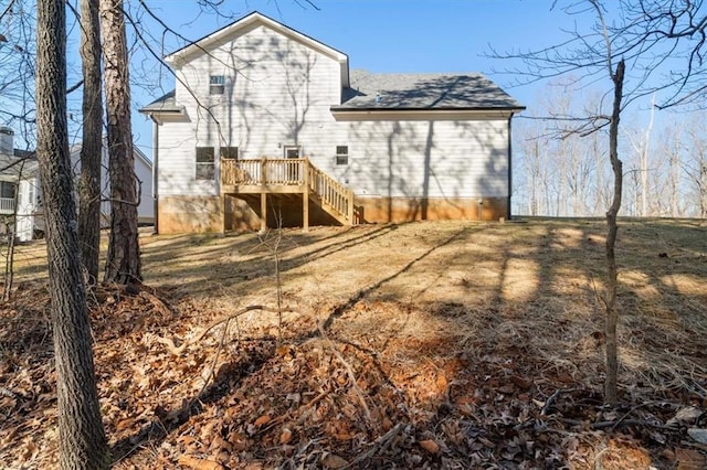 back of house featuring a deck and a lawn