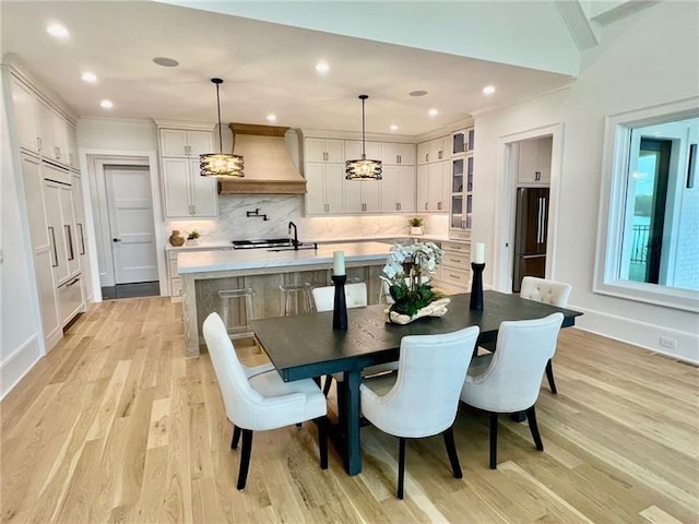 dining room with light wood-style flooring, baseboards, and recessed lighting