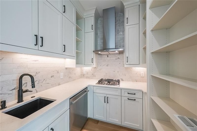 kitchen featuring open shelves, wall chimney exhaust hood, stainless steel appliances, a sink, and backsplash
