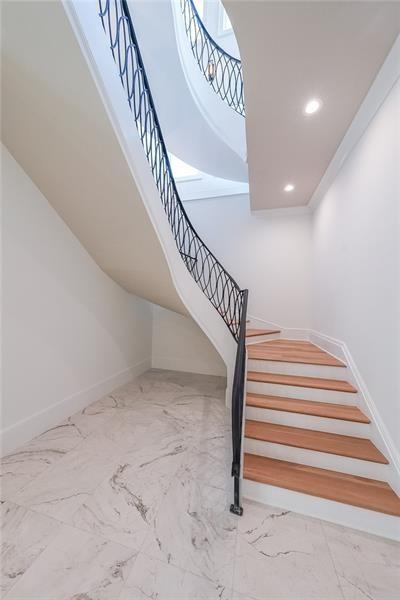 staircase with baseboards, recessed lighting, and marble finish flooring
