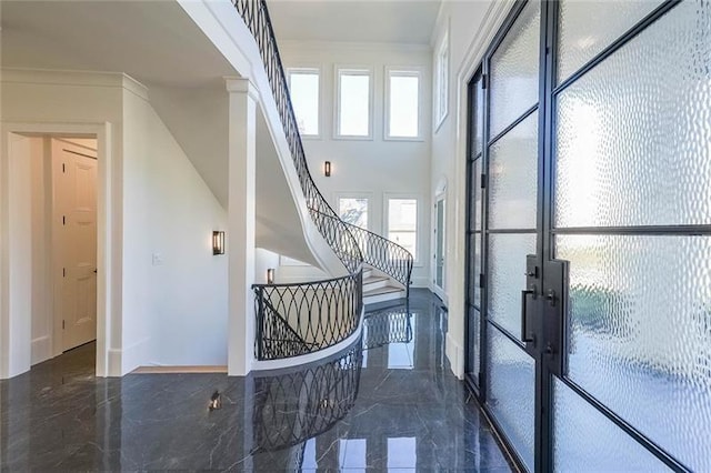 stairway featuring marble tiled floors, french doors, and crown molding