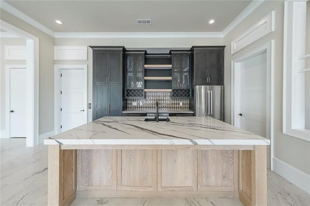 bar featuring high end fridge, tasteful backsplash, light marble finish floors, ornamental molding, and a sink
