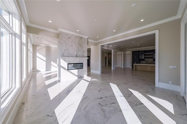 unfurnished living room featuring ornamental molding, a high end fireplace, recessed lighting, marble tiled floors, and baseboards