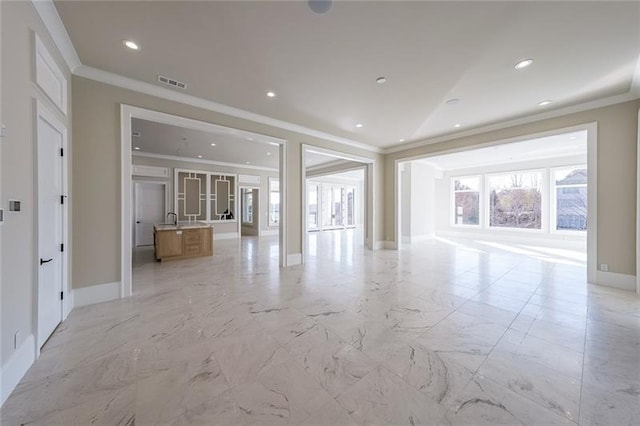 unfurnished living room featuring crown molding, baseboards, light marble finish floors, and recessed lighting