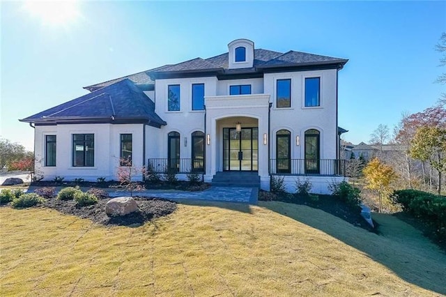 back of house featuring a lawn and stucco siding
