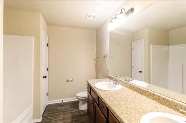 full bath with baseboards, a sink, and wood finished floors