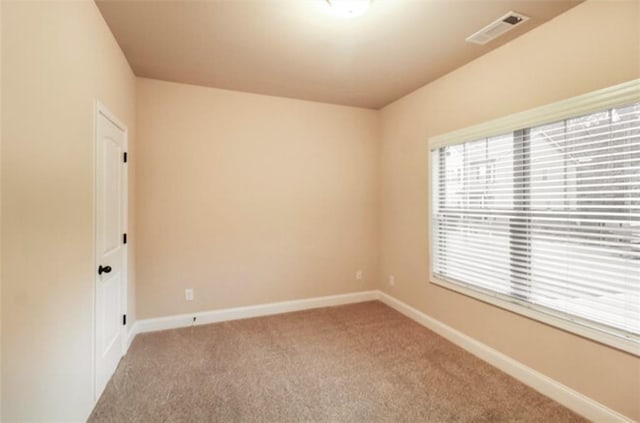unfurnished room with baseboards, visible vents, and carpet floors
