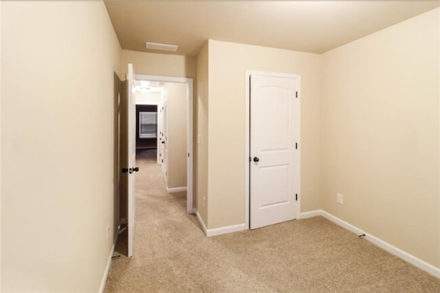 unfurnished bedroom with baseboards and light colored carpet