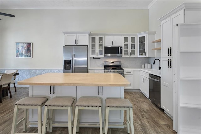 1491 Black Hickory Pl, Norcross, GA 30093 - kitchen featuring appliances with stainless steel finishes, a sink, a kitchen island, crown molding, and white cabinets