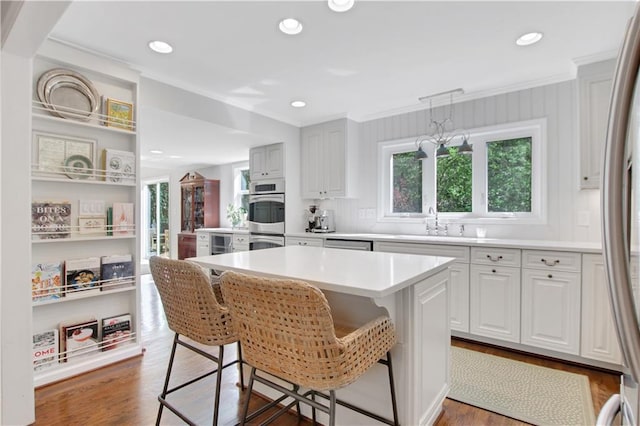 435 Grenock Cir, Atlanta, GA 30328 - kitchen with ornamental molding, a breakfast bar, a sink, appliances with stainless steel finishes, and light countertops