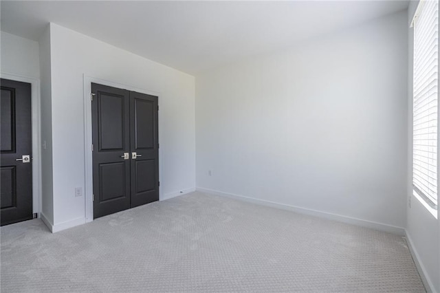 399 Pratt Dr SE, Atlanta, GA 30315 - unfurnished bedroom with light colored carpet, baseboards, and a closet