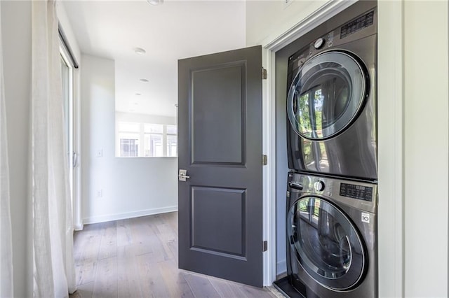 399 Pratt Dr SE, Atlanta, GA 30315 - laundry room featuring stacked washer and clothes dryer, plenty of natural light, wood finished floors, and baseboards