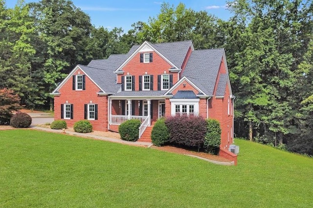 view of front of house with brick siding, a front lawn, and a porch