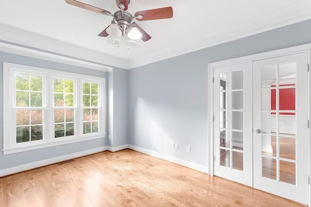 empty room with ceiling fan, hardwood / wood-style flooring, ornamental molding, and french doors