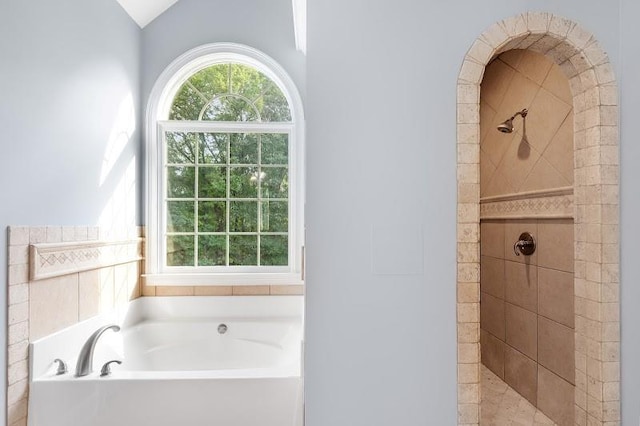 bathroom with a garden tub and a tile shower