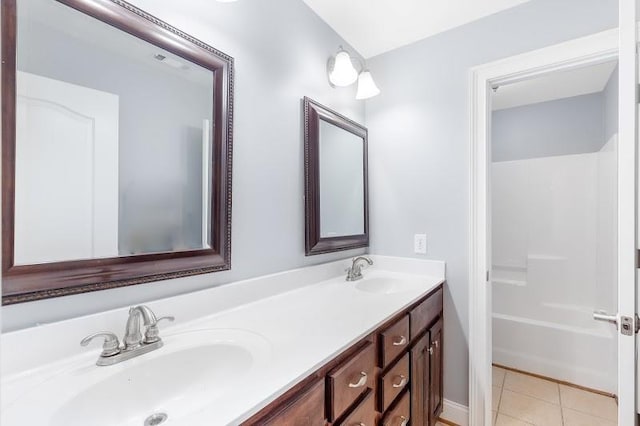 full bath featuring double vanity, tile patterned flooring, and a sink