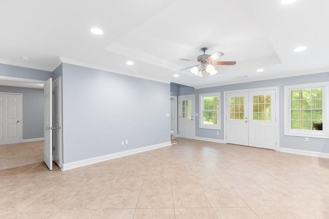 unfurnished living room with plenty of natural light, baseboards, a raised ceiling, and recessed lighting