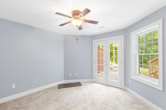 unfurnished room with ceiling fan, plenty of natural light, and light colored carpet