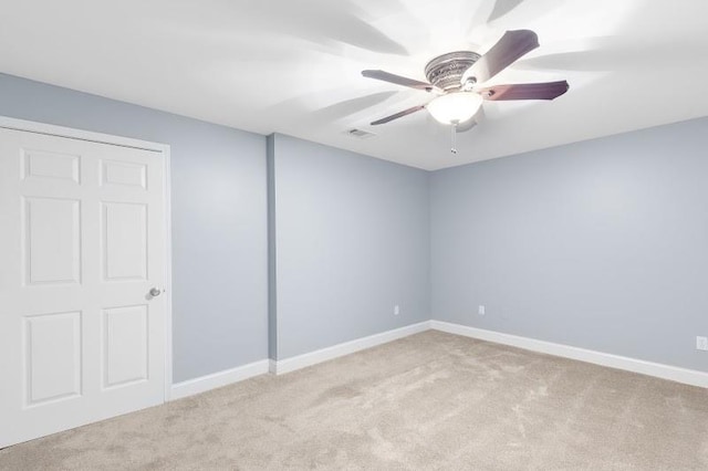 spare room featuring carpet floors, baseboards, visible vents, and a ceiling fan