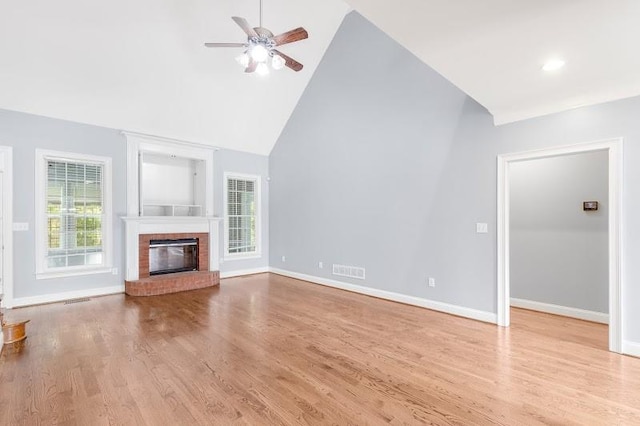 unfurnished living room featuring ceiling fan, a fireplace, high vaulted ceiling, and light hardwood / wood-style floors