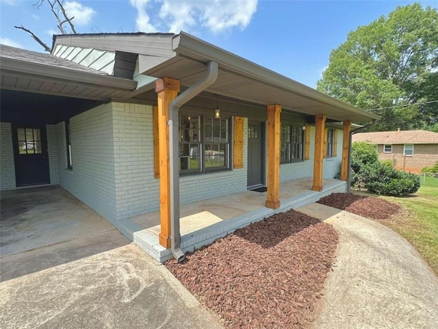 view of side of home featuring a carport and covered porch