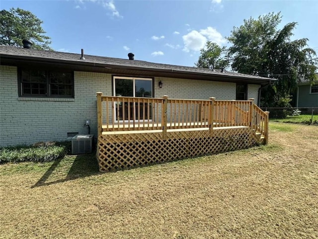 back of house featuring central AC unit, a wooden deck, and a lawn