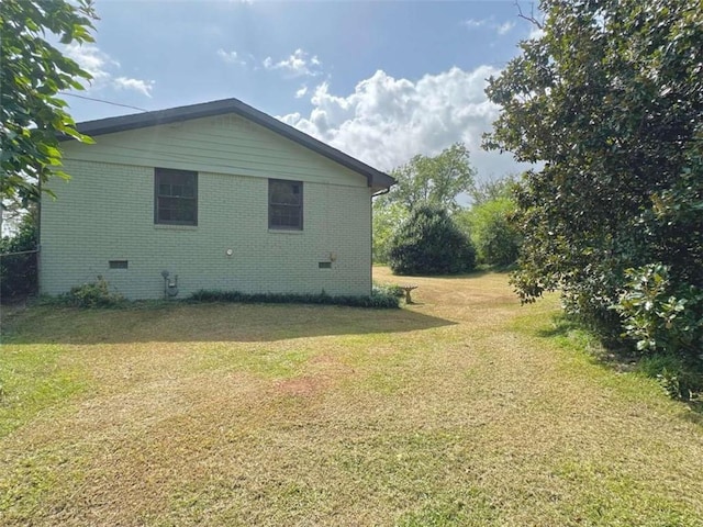 view of side of home with a yard