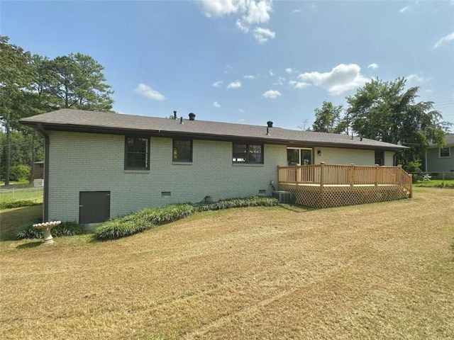 back of house featuring central AC unit, a deck, and a yard