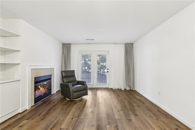 unfurnished room with dark hardwood / wood-style floors and a tile fireplace