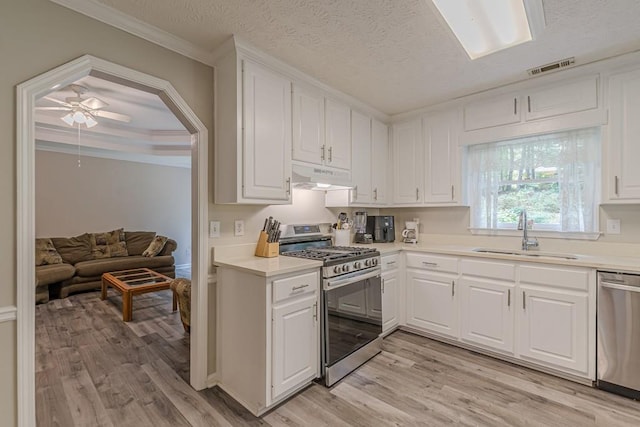 kitchen with sink, white cabinetry, stainless steel appliances, crown molding, and ceiling fan