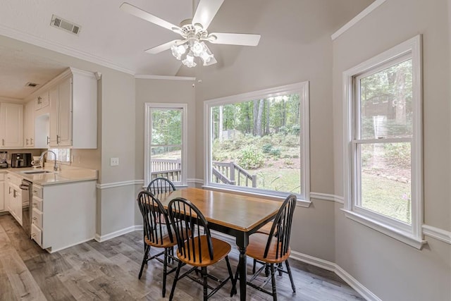 dining area with ceiling fan, light hardwood / wood-style flooring, plenty of natural light, and sink