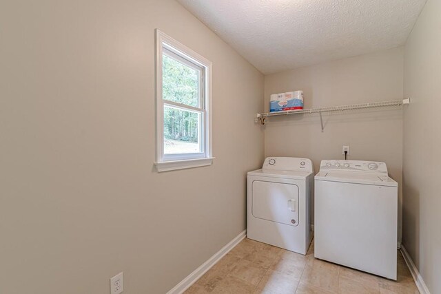 washroom featuring a textured ceiling and washer and dryer