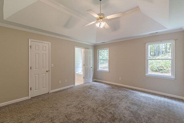 unfurnished bedroom with a tray ceiling, ceiling fan, ensuite bathroom, and crown molding